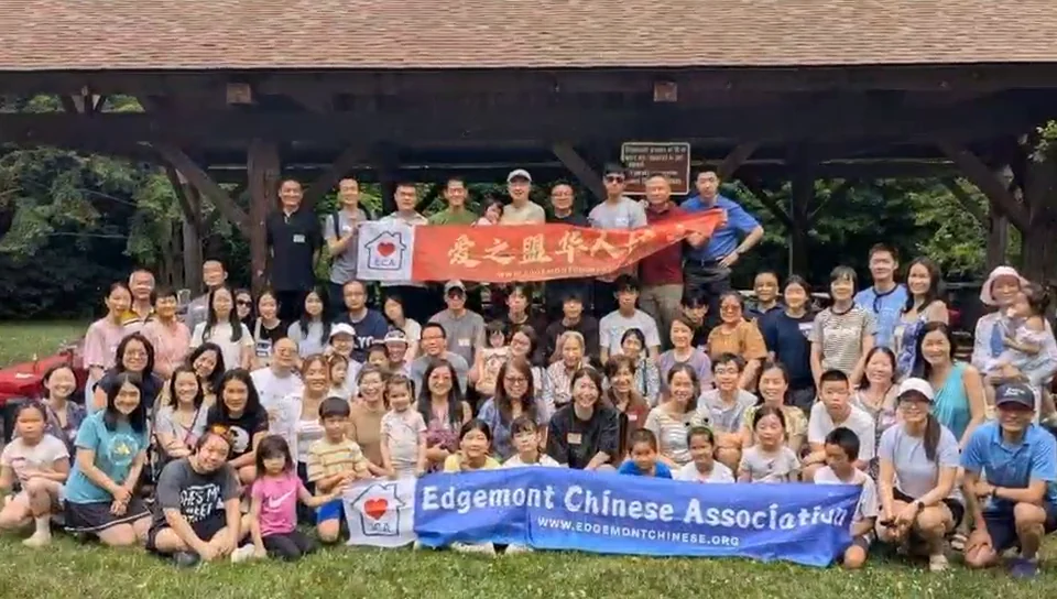 ECA 社区活动视频中的集体合影，参与者在爱之盟横幅前相聚