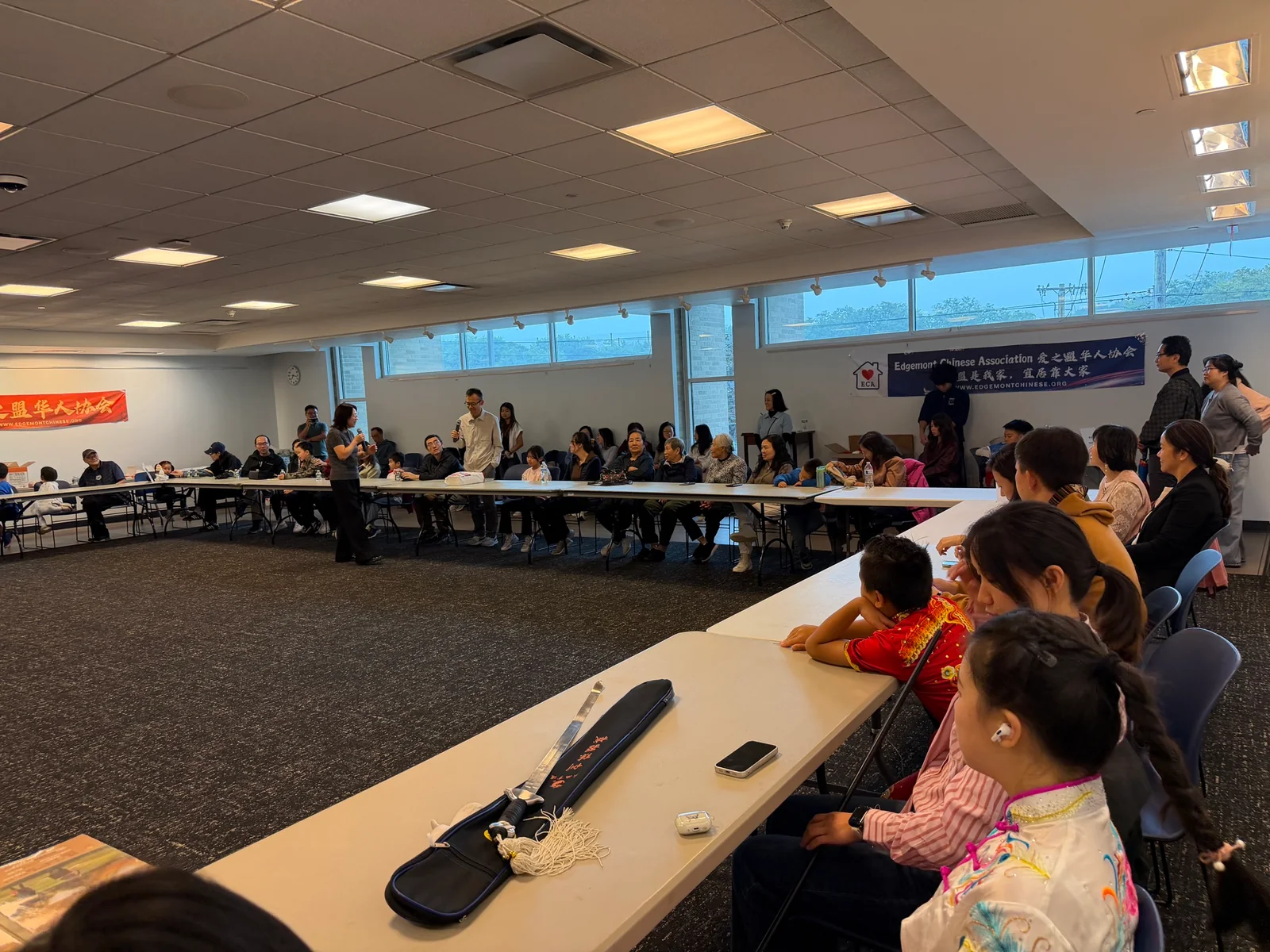 中秋迎新活动现场,参与者围坐交流,几位来宾手持话筒发言